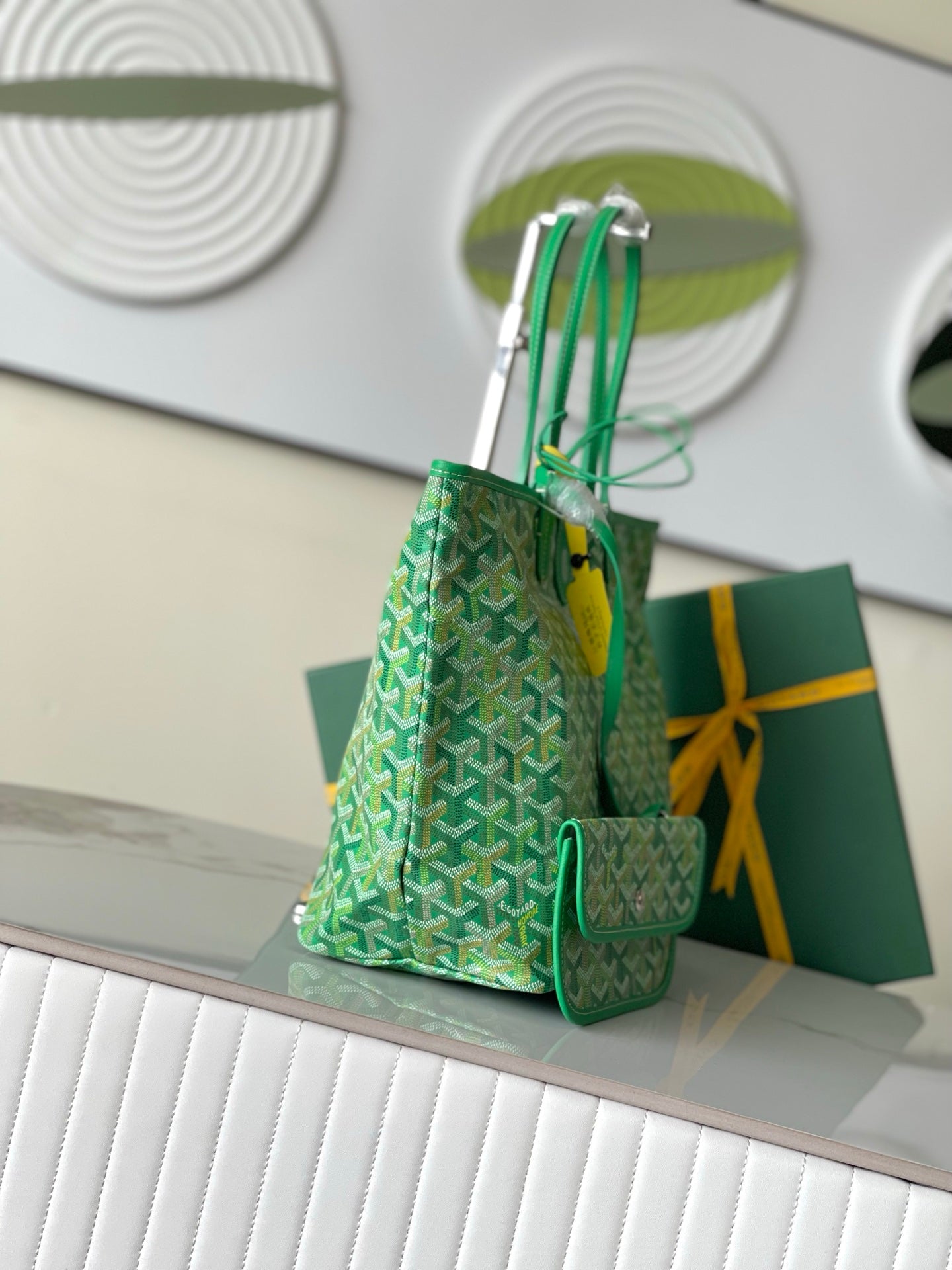 Green patterned tote bag with top handles and small attached pocket pouch