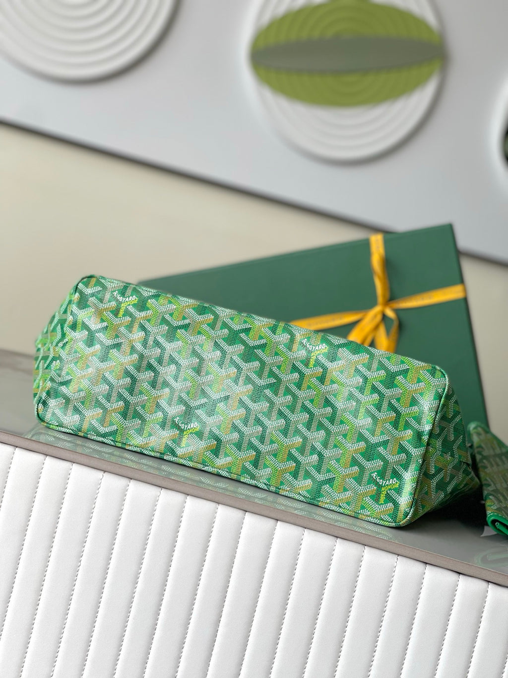 Green patterned tote bag with flat base and top handles, small pouch included
