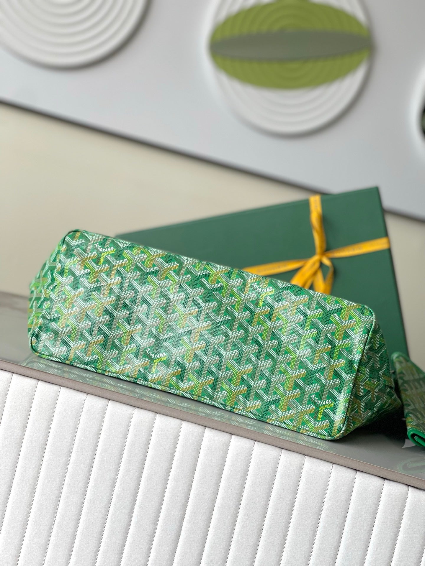 Green patterned tote bag with flat base and top handles, small pouch included