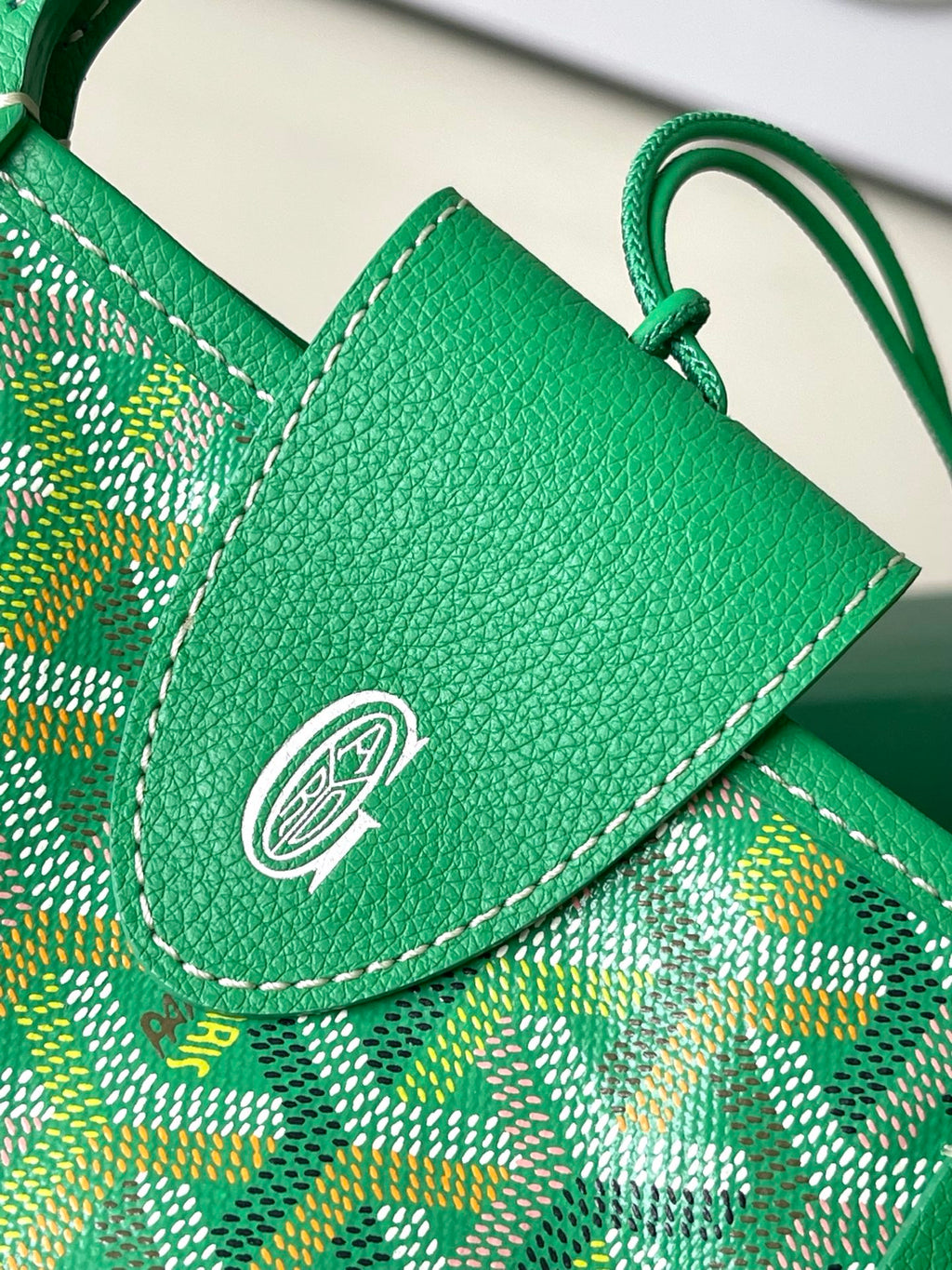 Green flap pocket with embossed logo on patterned tote bag