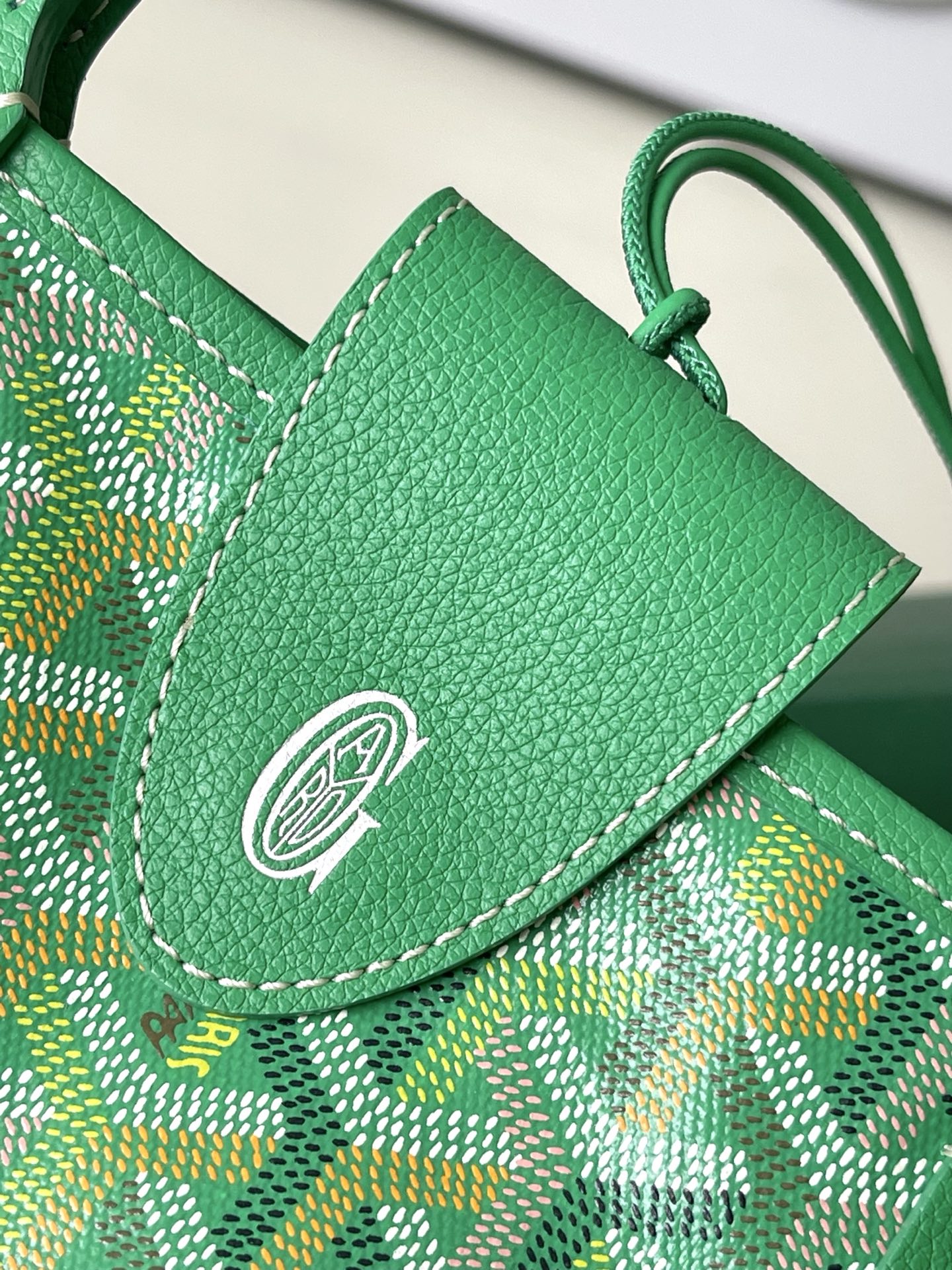 Green flap pocket with embossed logo on patterned tote bag