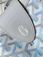 Close-up of light blue-and-white patterned flap pocket with silver logo emblem