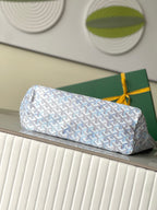 Light blue-and-white patterned designer tote bag with top handles, resting on a surface
