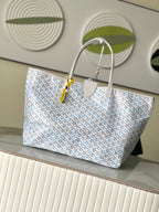 Light blue patterned tote bag with long top handles and small luggage tag detail