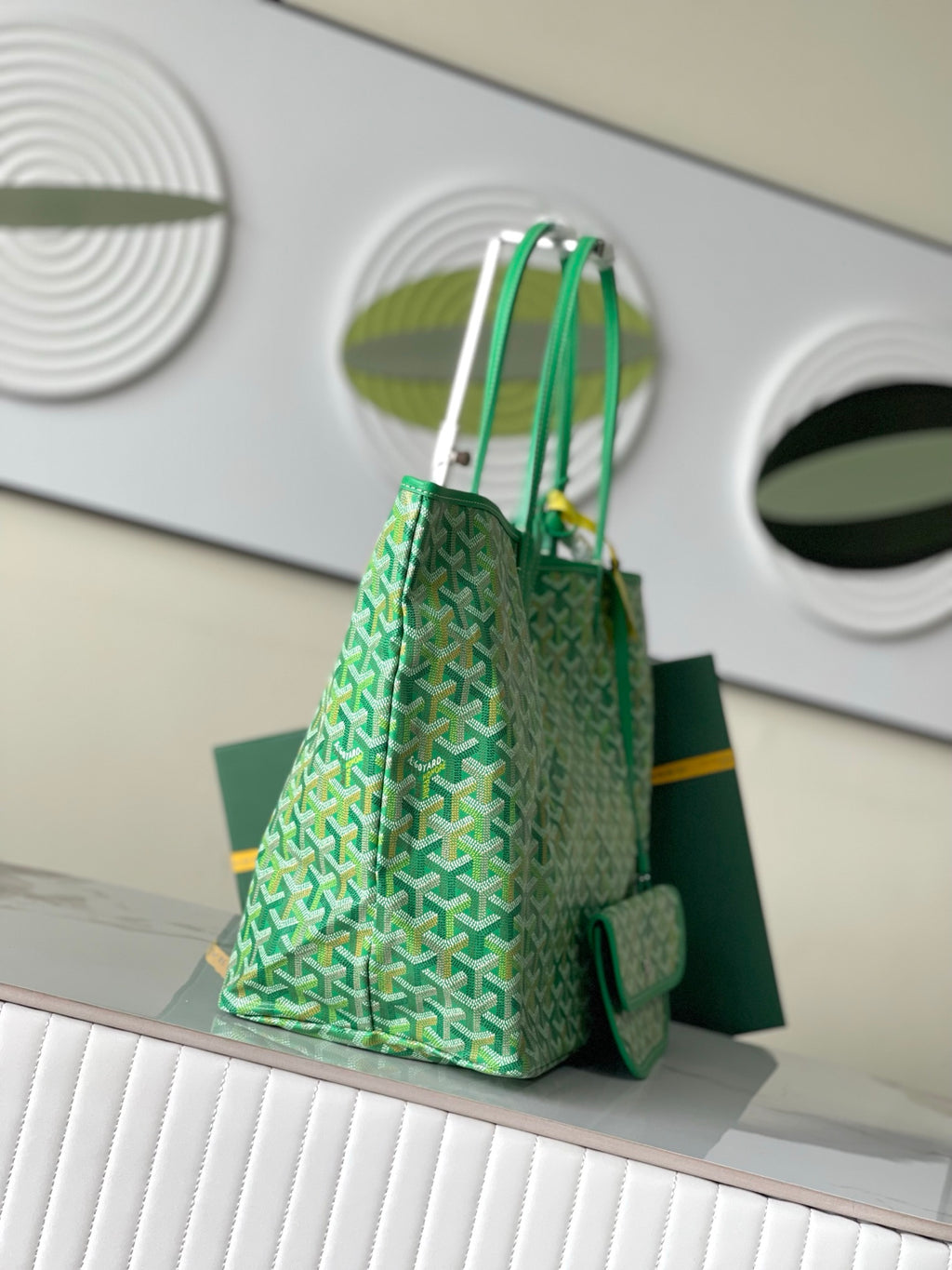 Green patterned tote bag with two vertical handles and side pocket flap