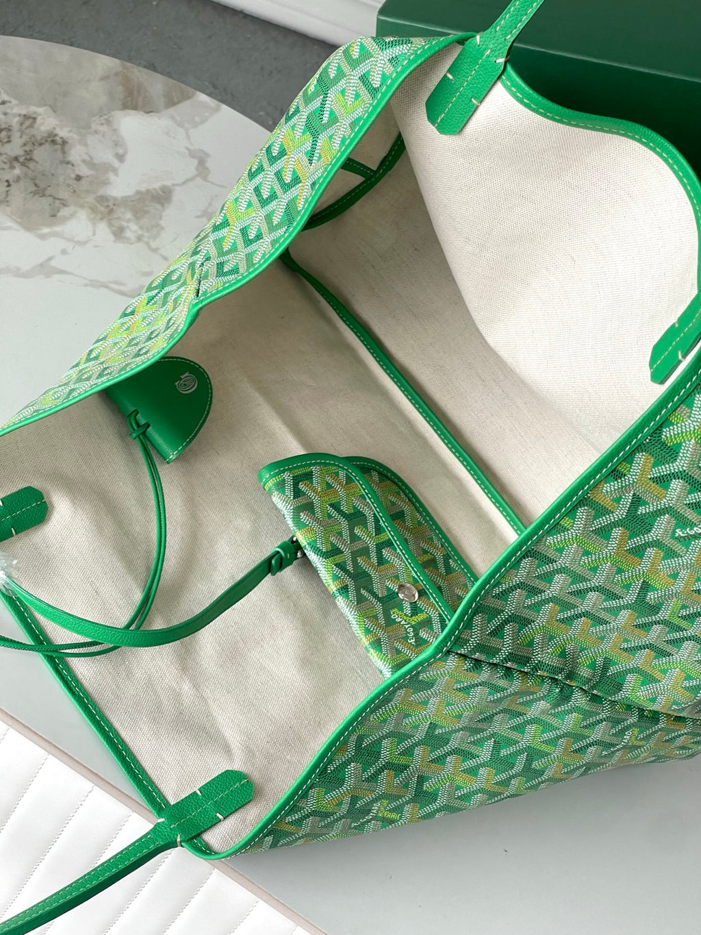 Green patterned tote bag open, showing cream lining and small interior pouch