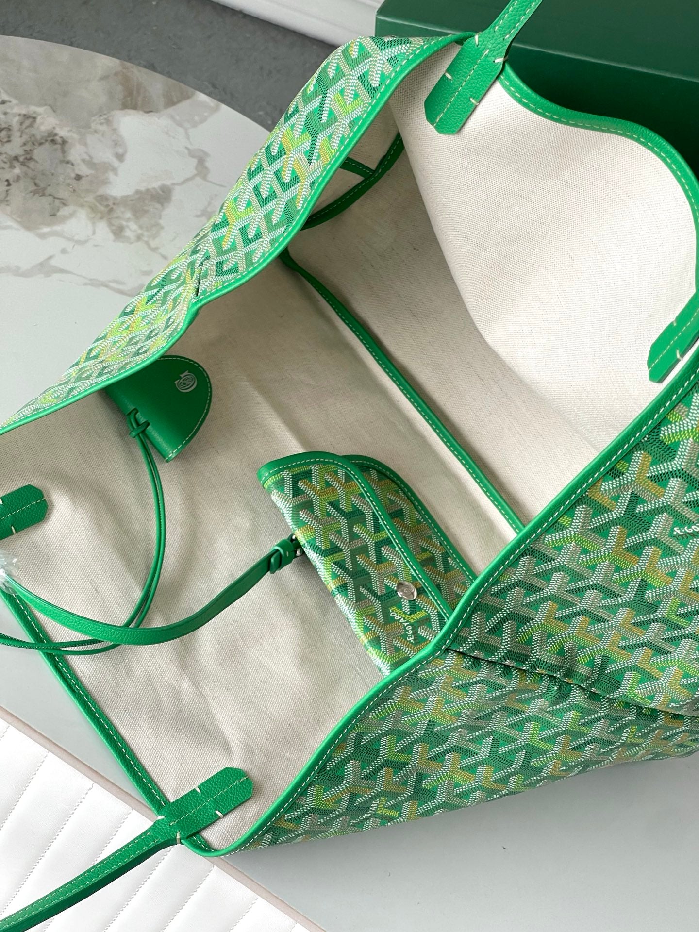 Green patterned tote bag open, showing cream lining and small interior pouch