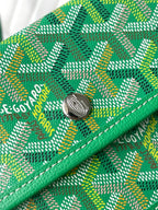 Green patterned tote bag with round metal clasp and stitched logo detail