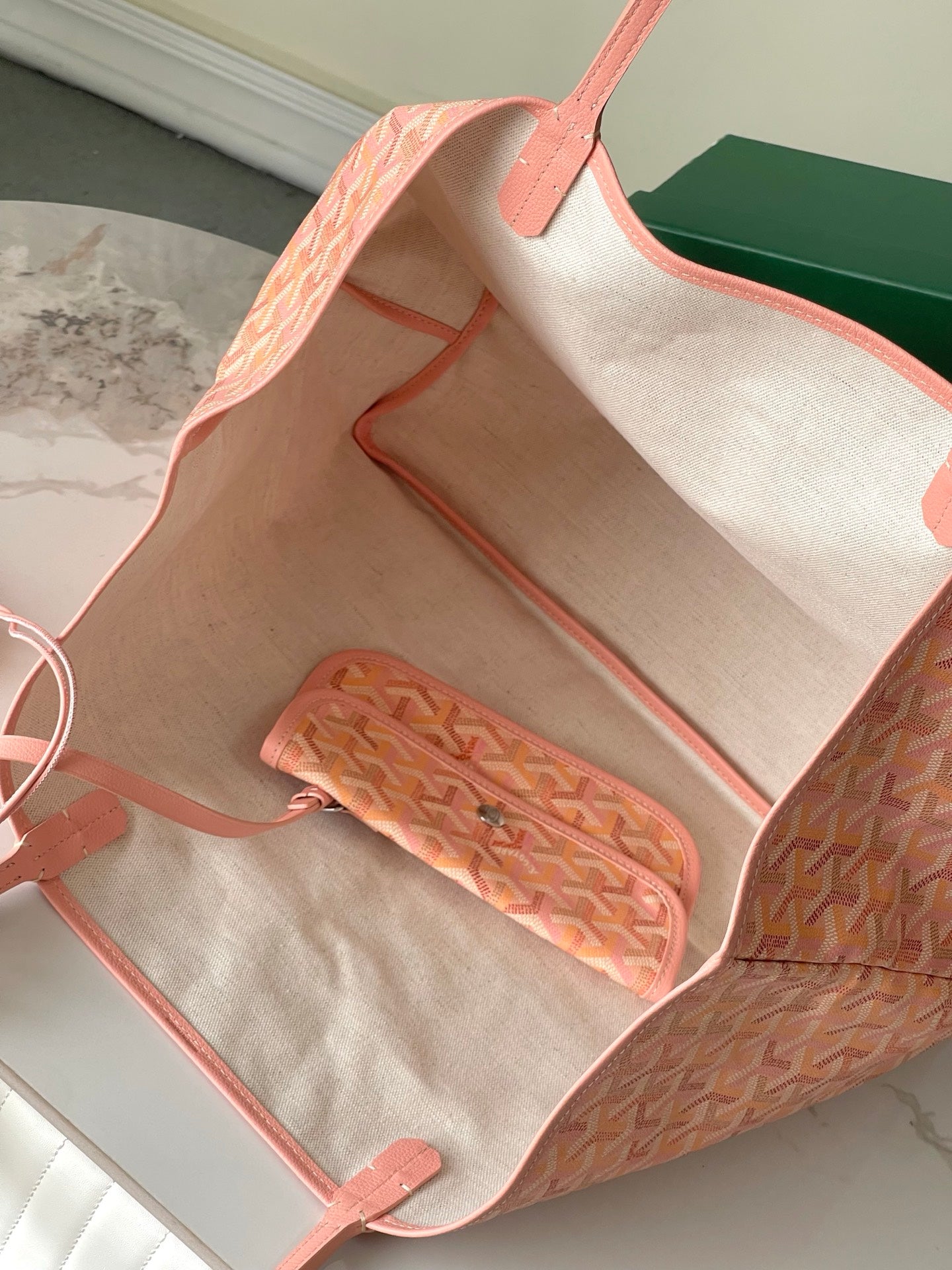 Open pink patterned tote bag interior with zip pouch and leather trim