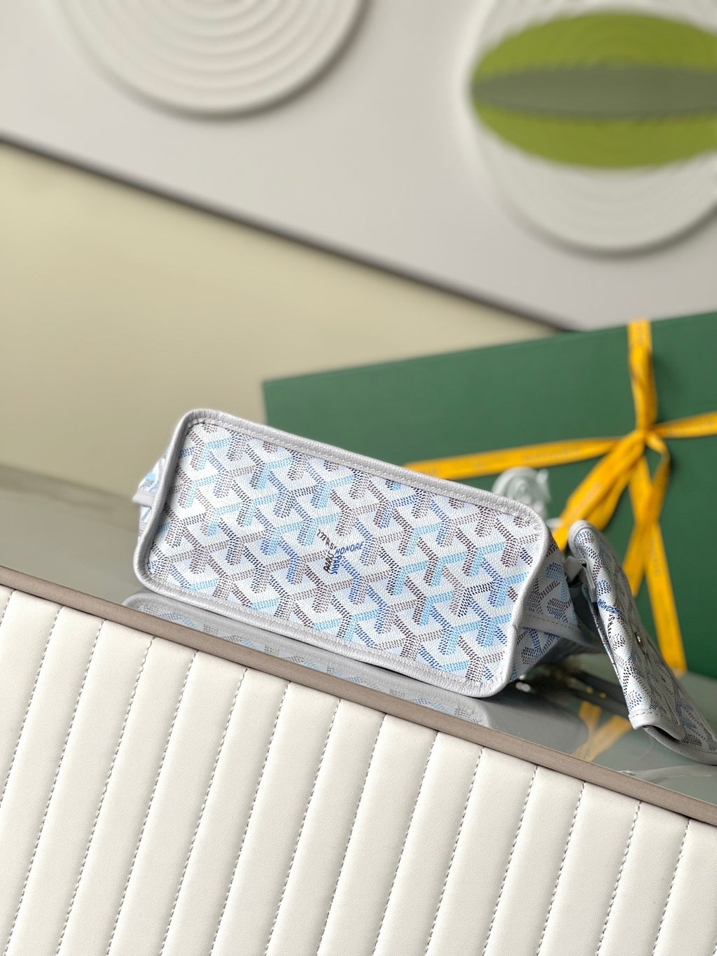 Light blue patterned zip pouch with gray trim and top wrist strap, side view