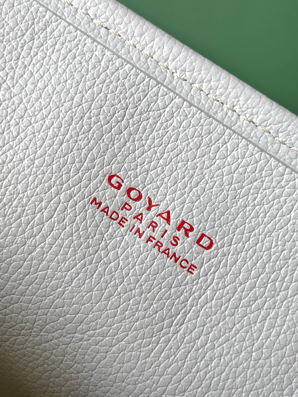 Light gray leather base with embossed Goyard Paris France logo text