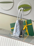 Light blue patterned tote bag with gray handles and round emblem tag, side view