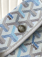 Light blue patterned pocket with round metal snap button and engraved charm