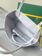 Open top of light blue patterned tote bag showing gray interior and hanging strap