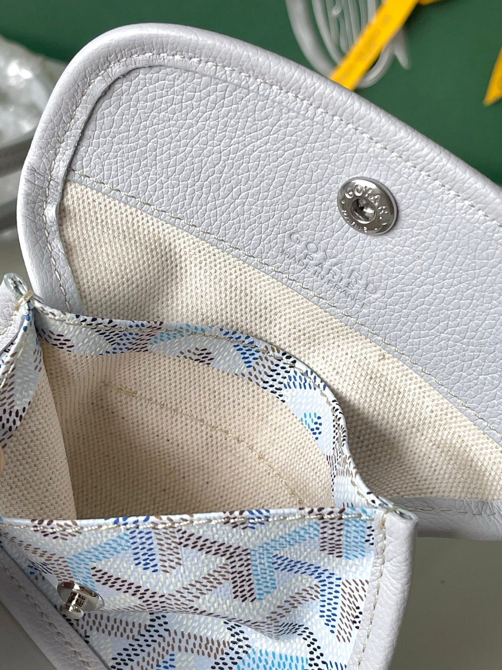 Interior pocket of light blue patterned tote with gray snap button and stitched lining