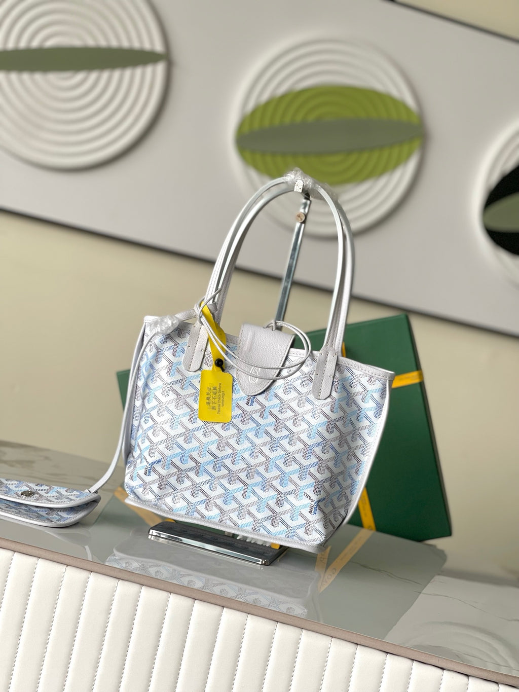 Light blue patterned tote bag with structured gray handles and yellow tag, front view