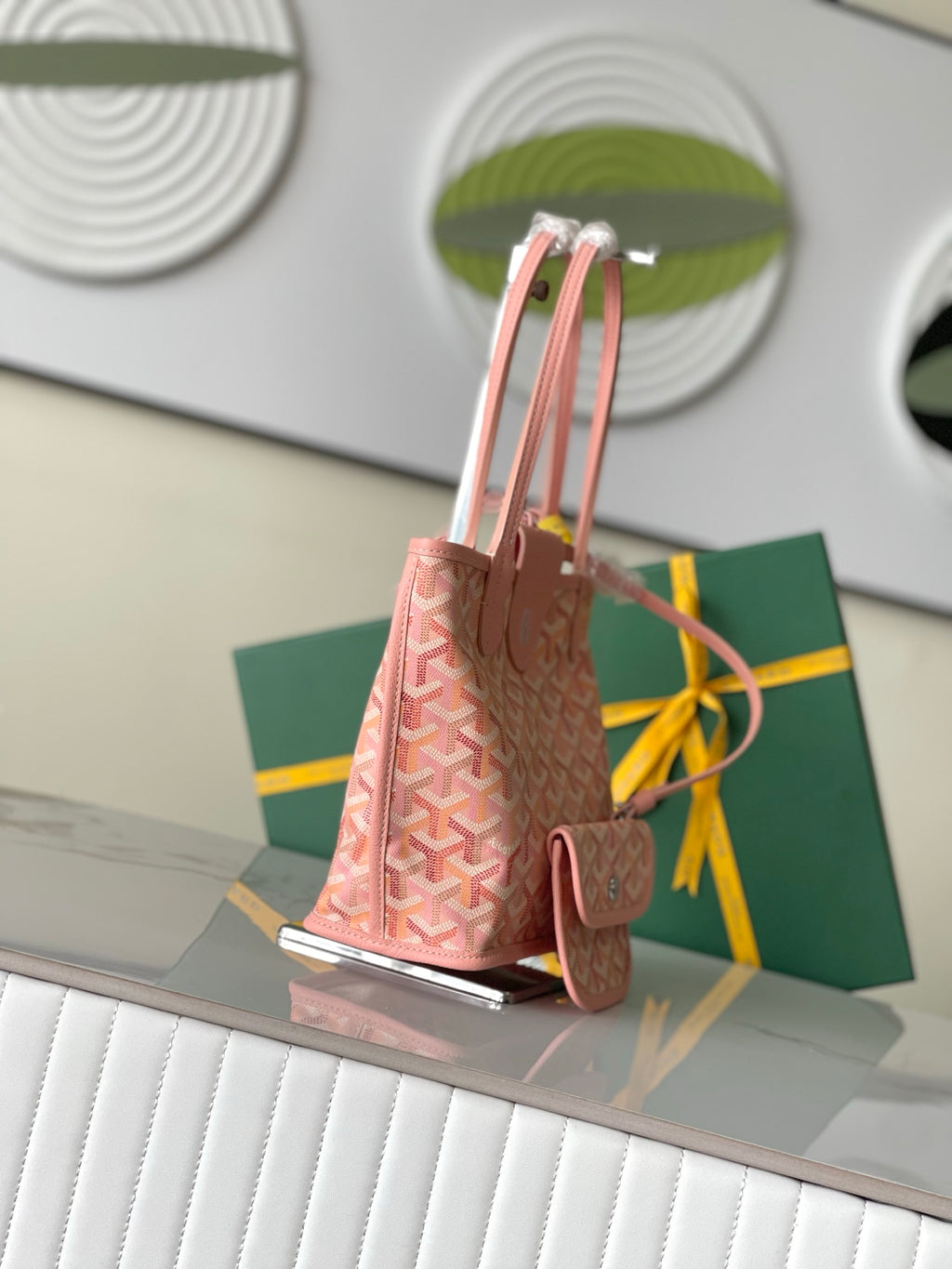 Pink patterned tote bag with side panels and top handles, showing bag silhouette and tag.