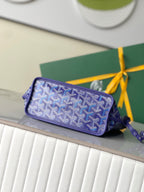 Goyard patterned zip pouch in blue with wrist strap on glass shelf