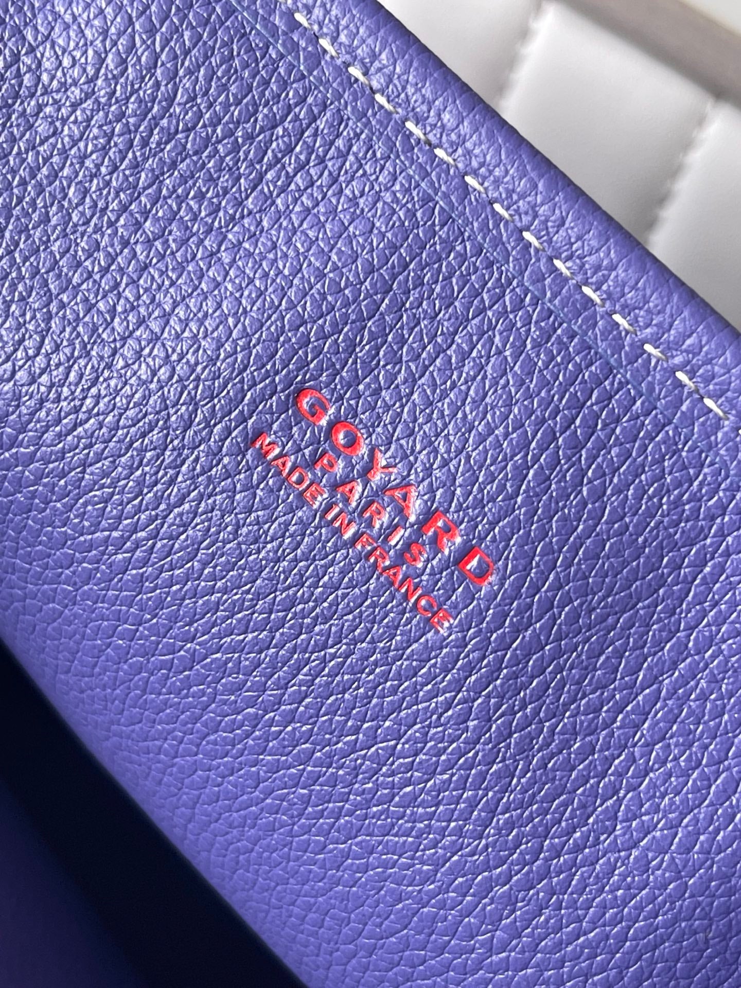 Blue leather panel with embroidered Goyard Paris logo and dashed stitching