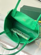 Open green Goyard handbag showing interior lining and zipped pouch pocket