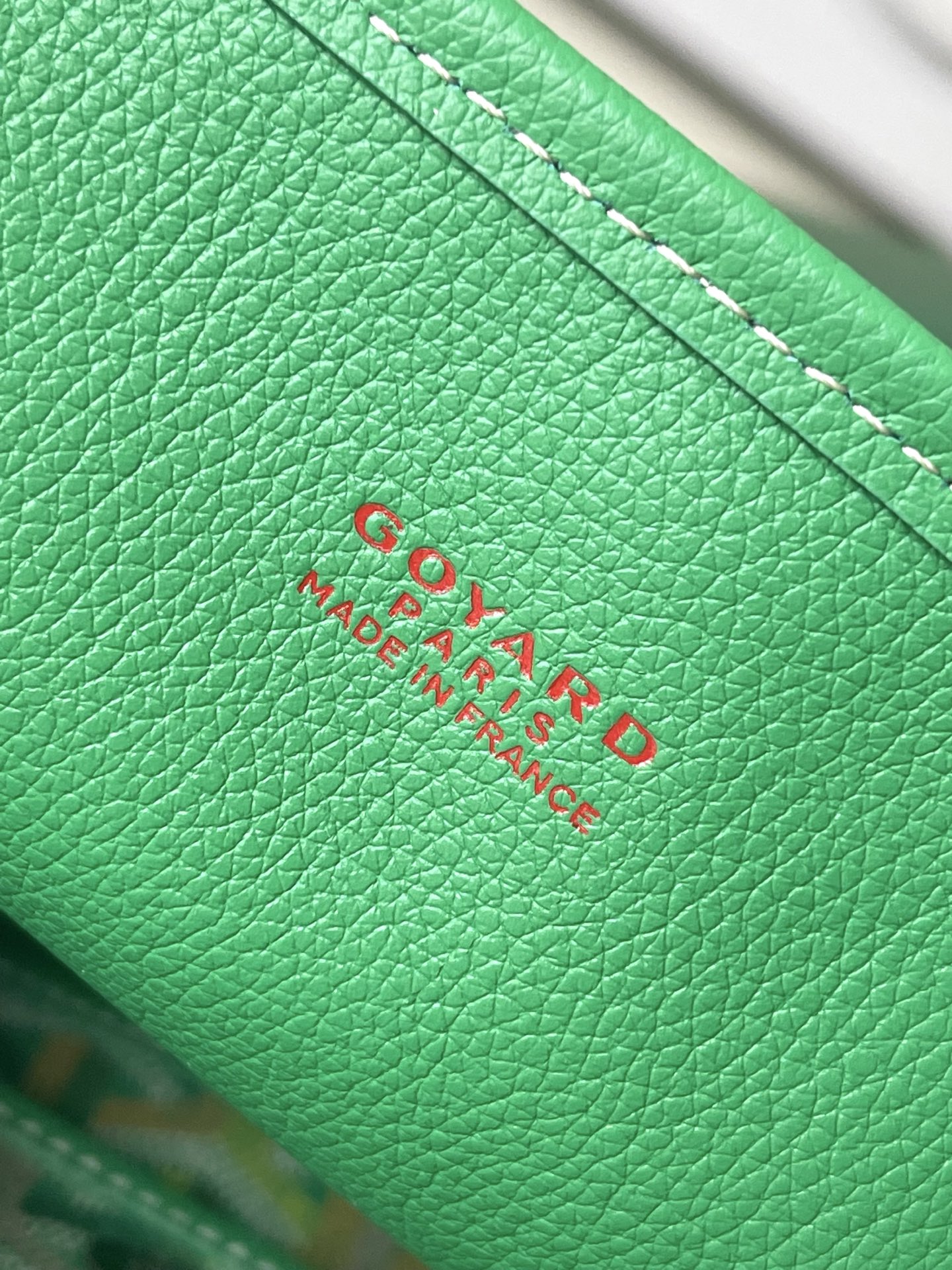 Green Goyard leather label patch with embossed logo text