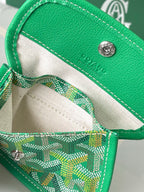 Green Goyard handbag interior view with striped lining, zipper pocket, and snap hardware