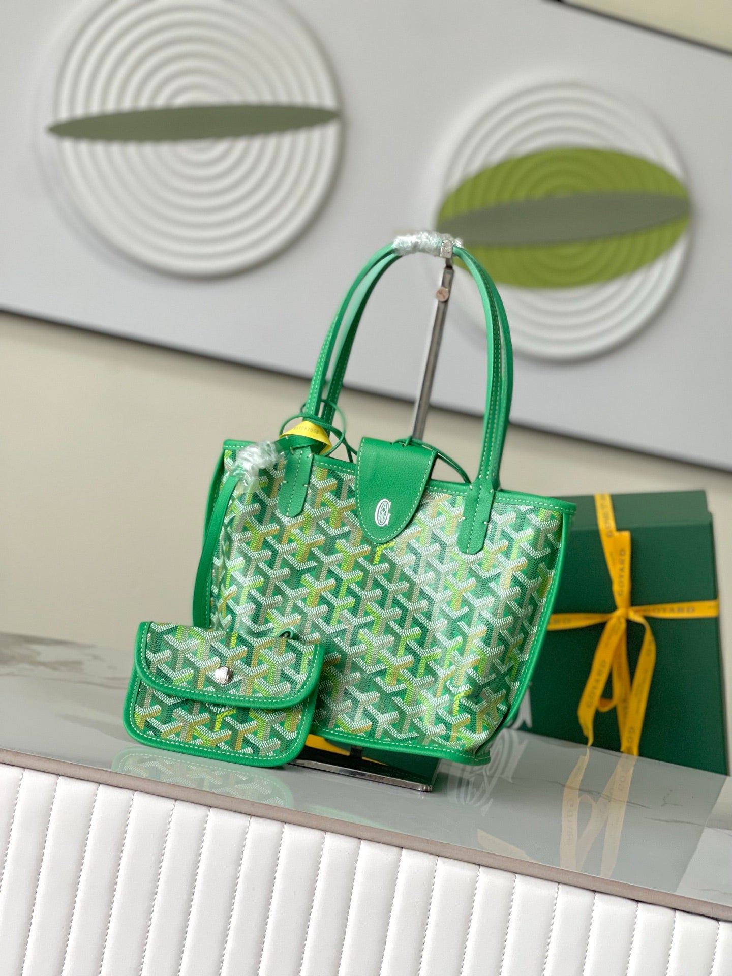 Green Goyard handbag with two top handles, patterned front, and leather-trimmed front pocket