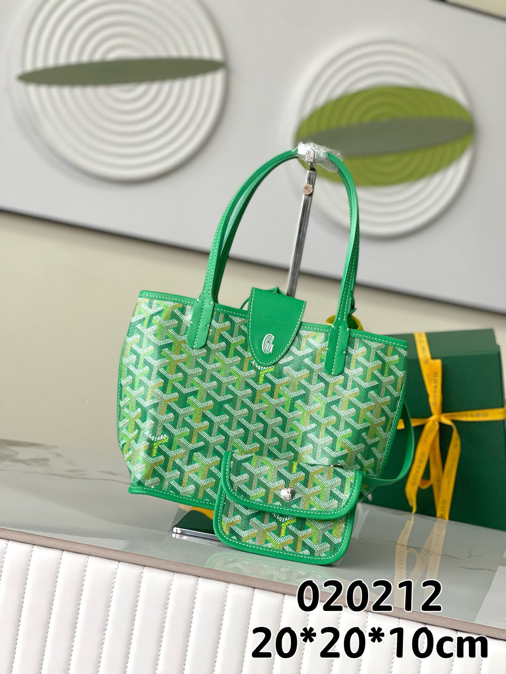 Green Goyard handbag with patterned sides, leather trim, top handles, and front pocket