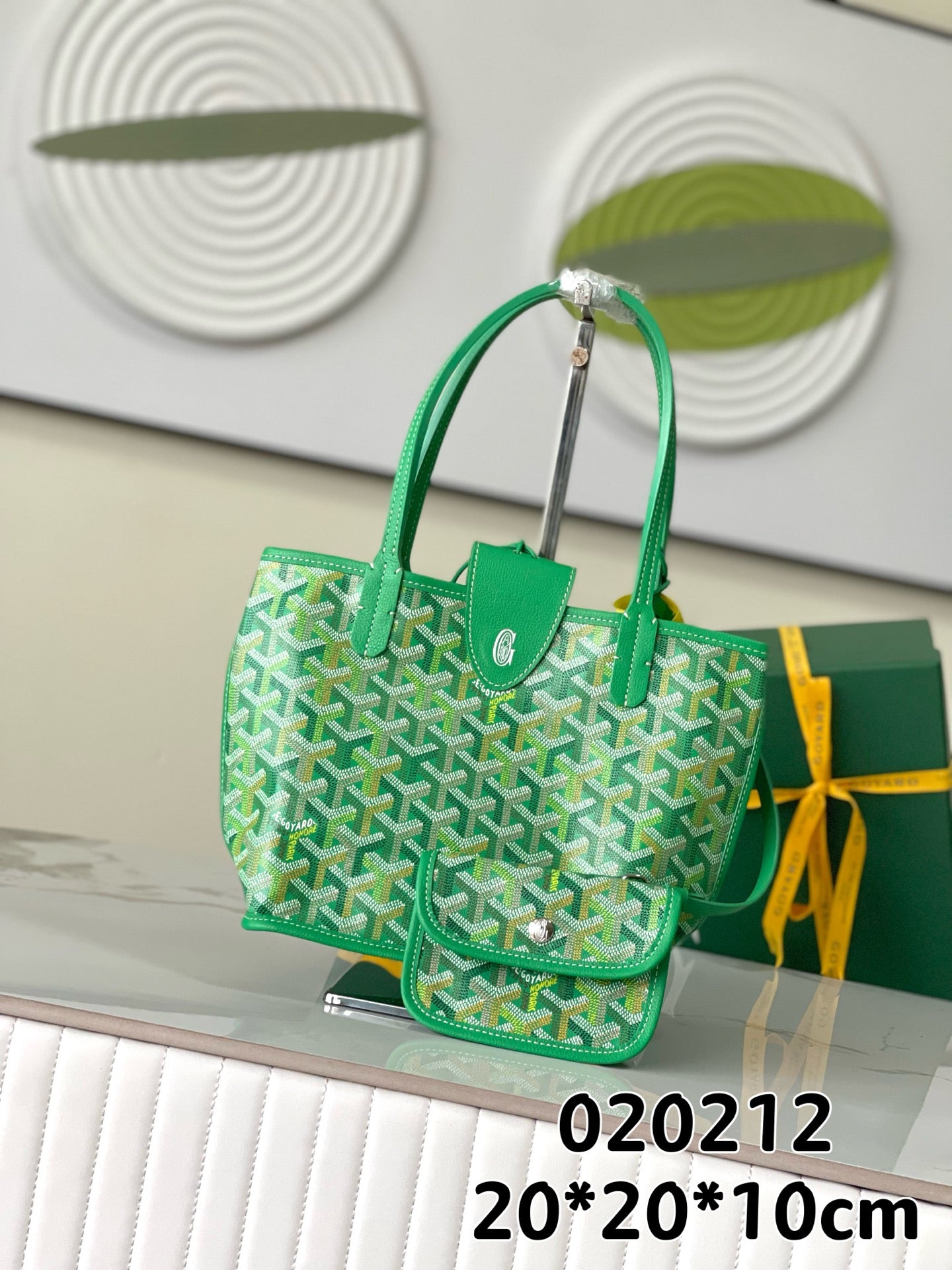 Green Goyard handbag with patterned sides, leather trim, top handles, and front pocket