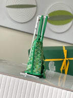 Green Goyard handbag viewed from side with structured shape, patterned canvas, and top handles
