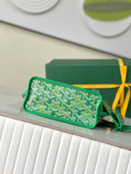 Green Goyard patterned mini pouch with zipper top, short handle, and leather trim