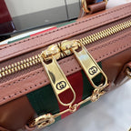 Brown leather bag with green-and-red stripe and gold zipper pull.