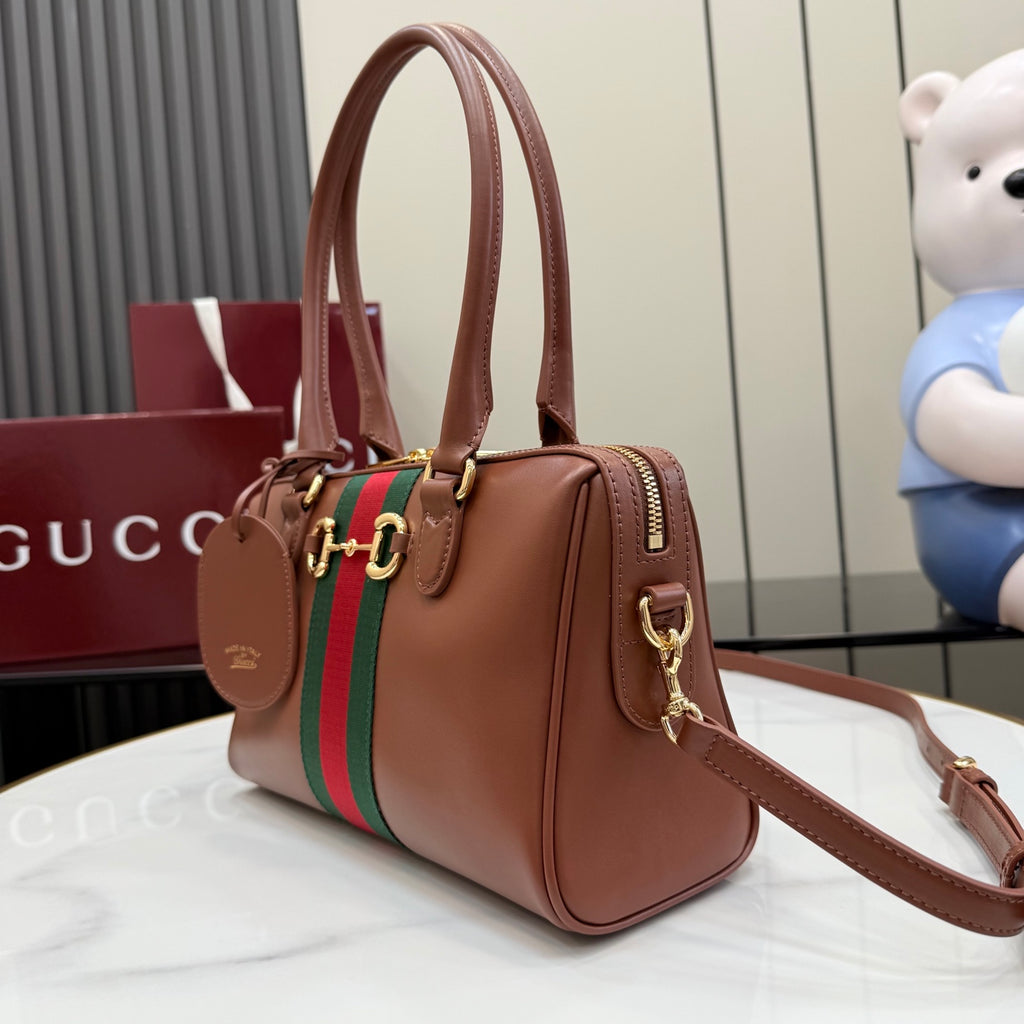 Brown leather handbag with green/red stripe, gold hardware, and adjustable shoulder strap.