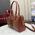 Brown leather handbag with green/red stripe, gold hardware, and adjustable shoulder strap.
