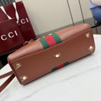 Brown leather clutch-style bag with green-and-red web stripe and gold studs.