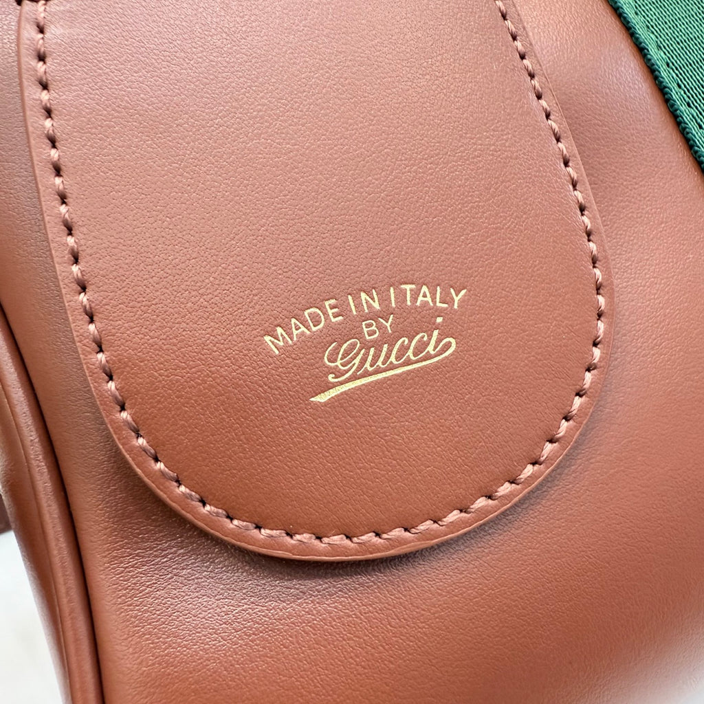 Gucci leather bag flap with Made in Italy Gucci logo and stitched edge