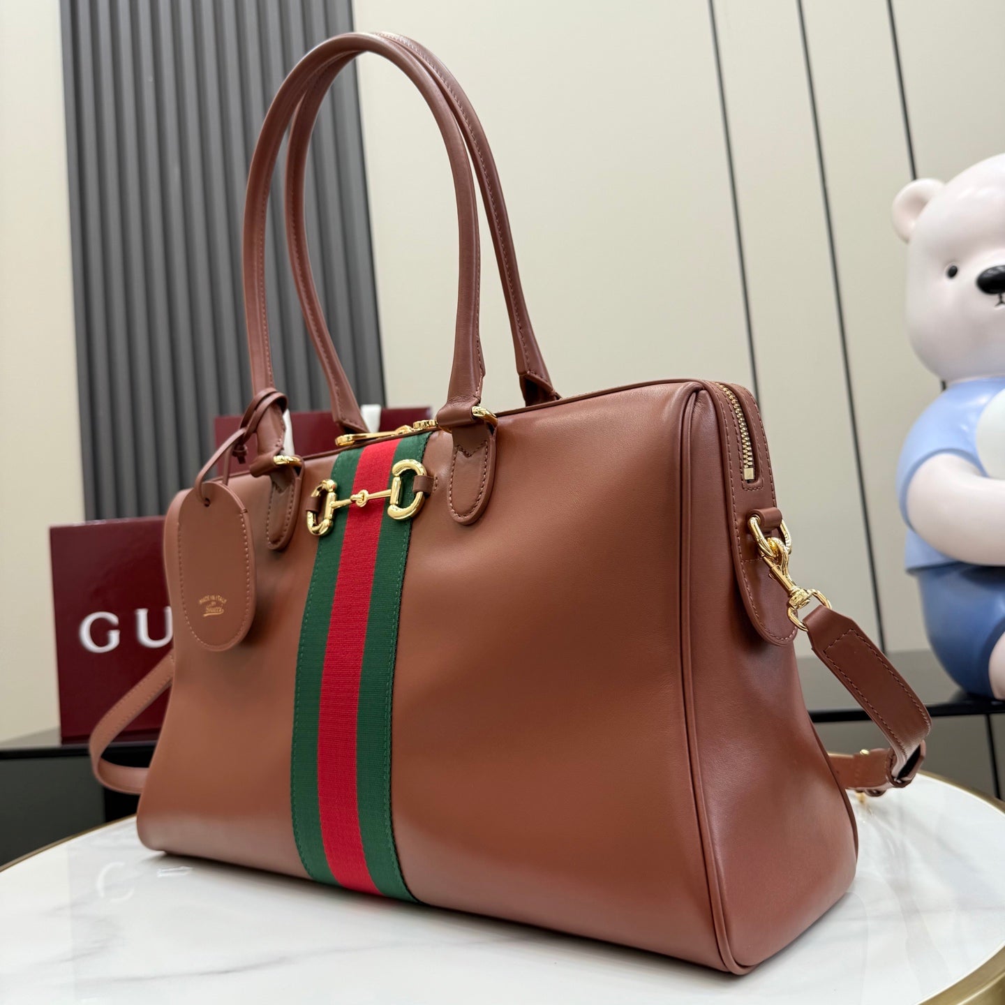 Brown Gucci leather tote bag with green-and-red stripe and gold-tone side rings