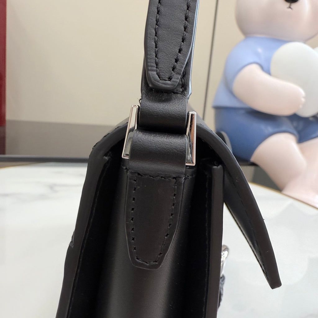 Black leather top-handle section with stitched handle loops and silver-tone connector hardware