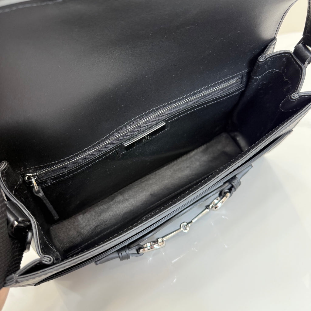 Black leather bag interior view with zippered pocket and silver-tone zipper pull