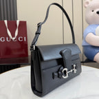 Black leather shoulder bag with flap, curved handle, and silver-tone horsebit clasp