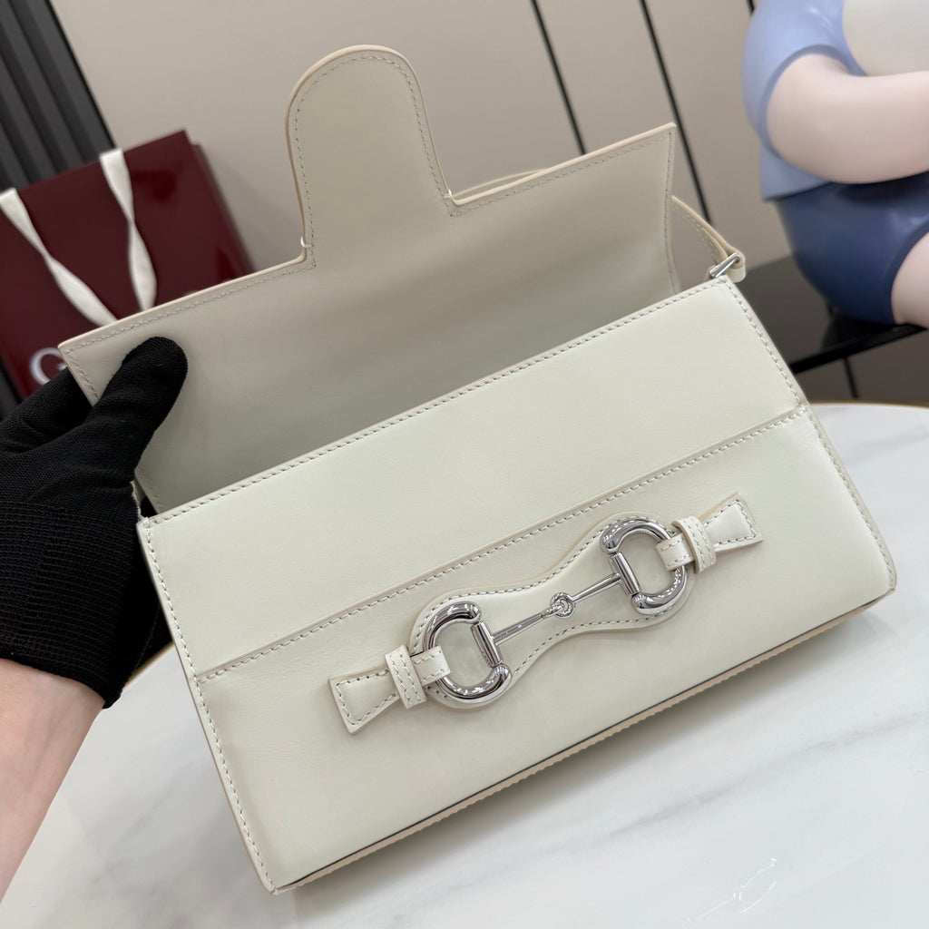 Cream handbag with flap closure, front metal clasp, and optional shoulder strap opening