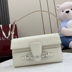 Cream shoulder bag with top flap, front hardware detail, and adjustable strap handles