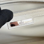 Gucci mini bag inside view with Gucci leather patch and silver zipper track.