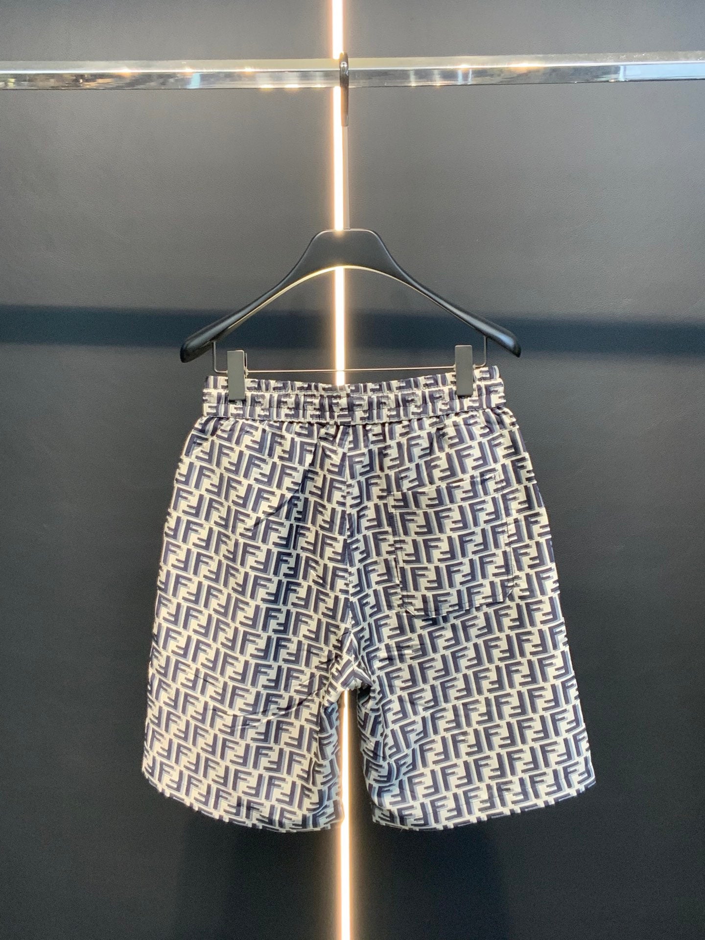 Dior logo-pattern shorts on hanger, full front view, navy and white print.