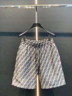 Dior logo-pattern shorts on hanger, navy and white, straight silhouette.