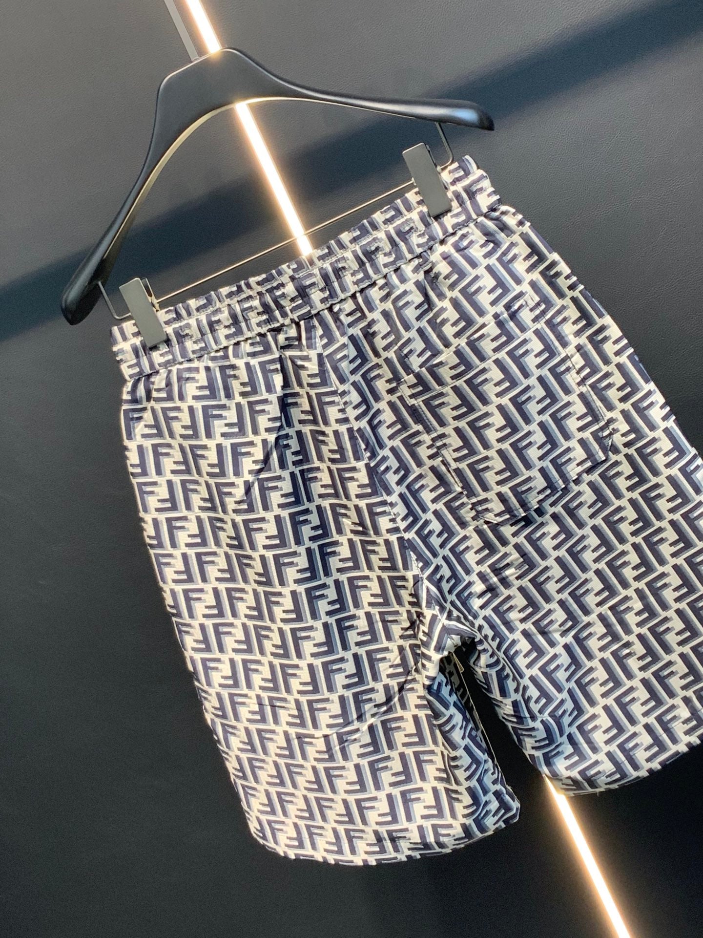 Dior logo-pattern shorts on hanger, angled front view with belt loops.