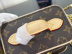 Monogram bag strap and latch close-up with white tissue on brown canvas
