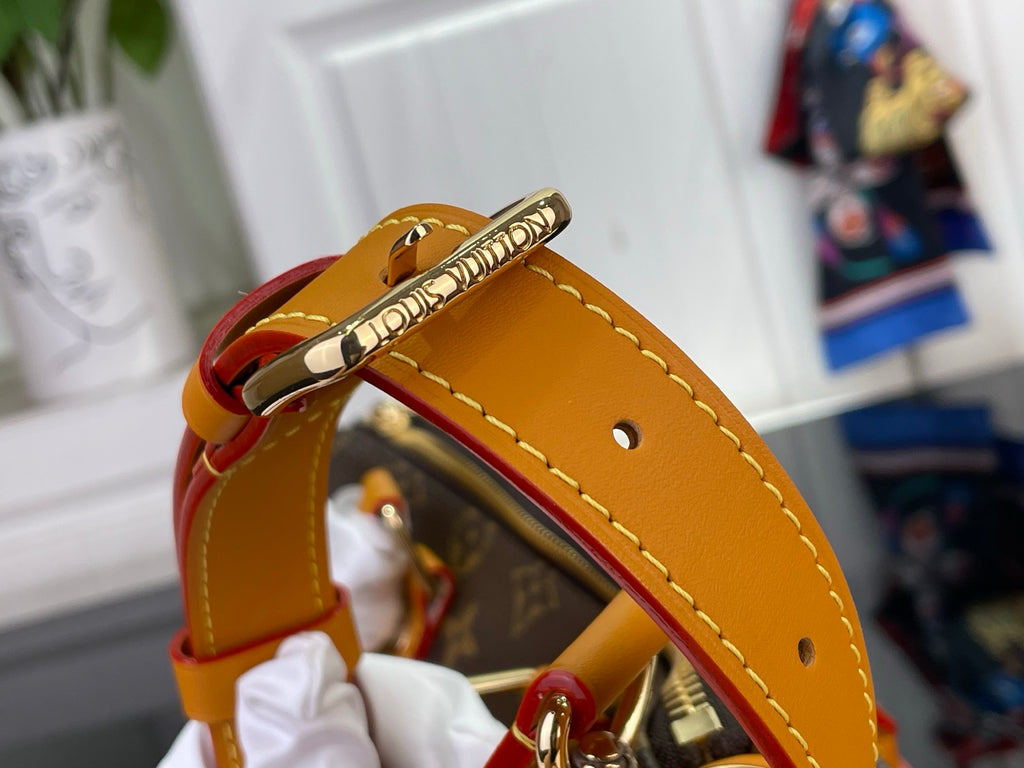 Louis Vuitton monogram bag strap end with orange leather and gold eyelets