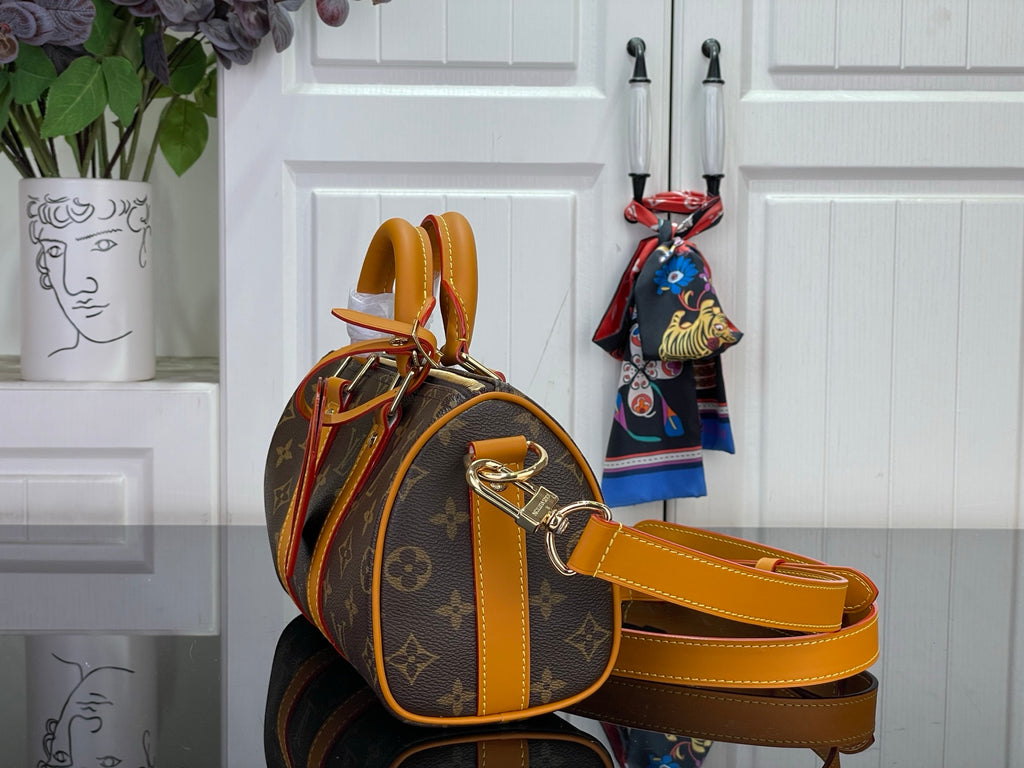 Louis Vuitton monogram handbag with orange leather strap and side profile view
