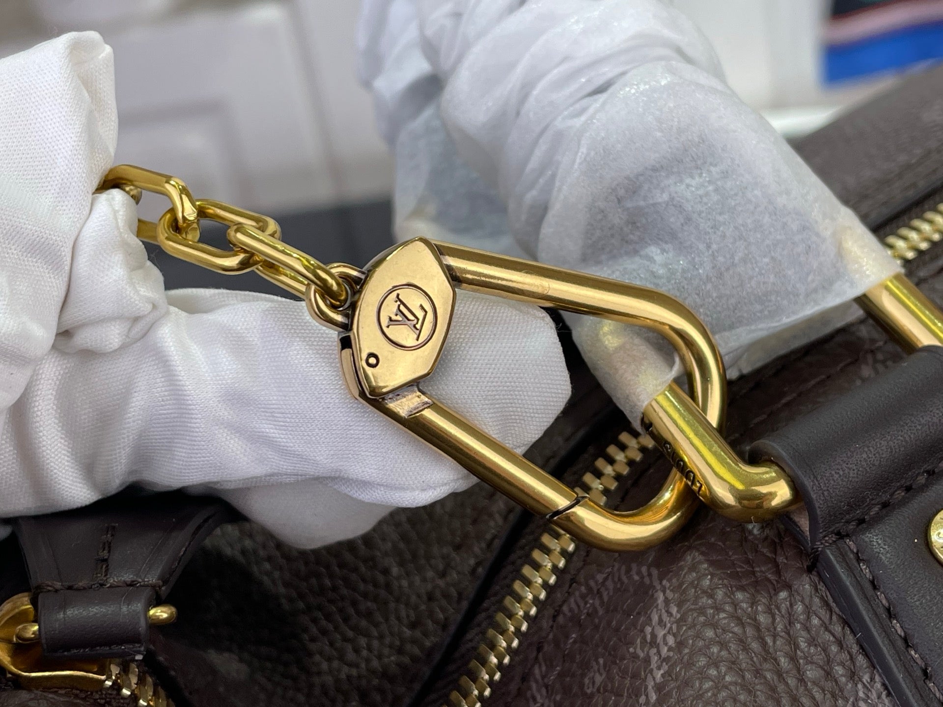 Louis Vuitton bag gold clasp and chain link on dark monogram leather
